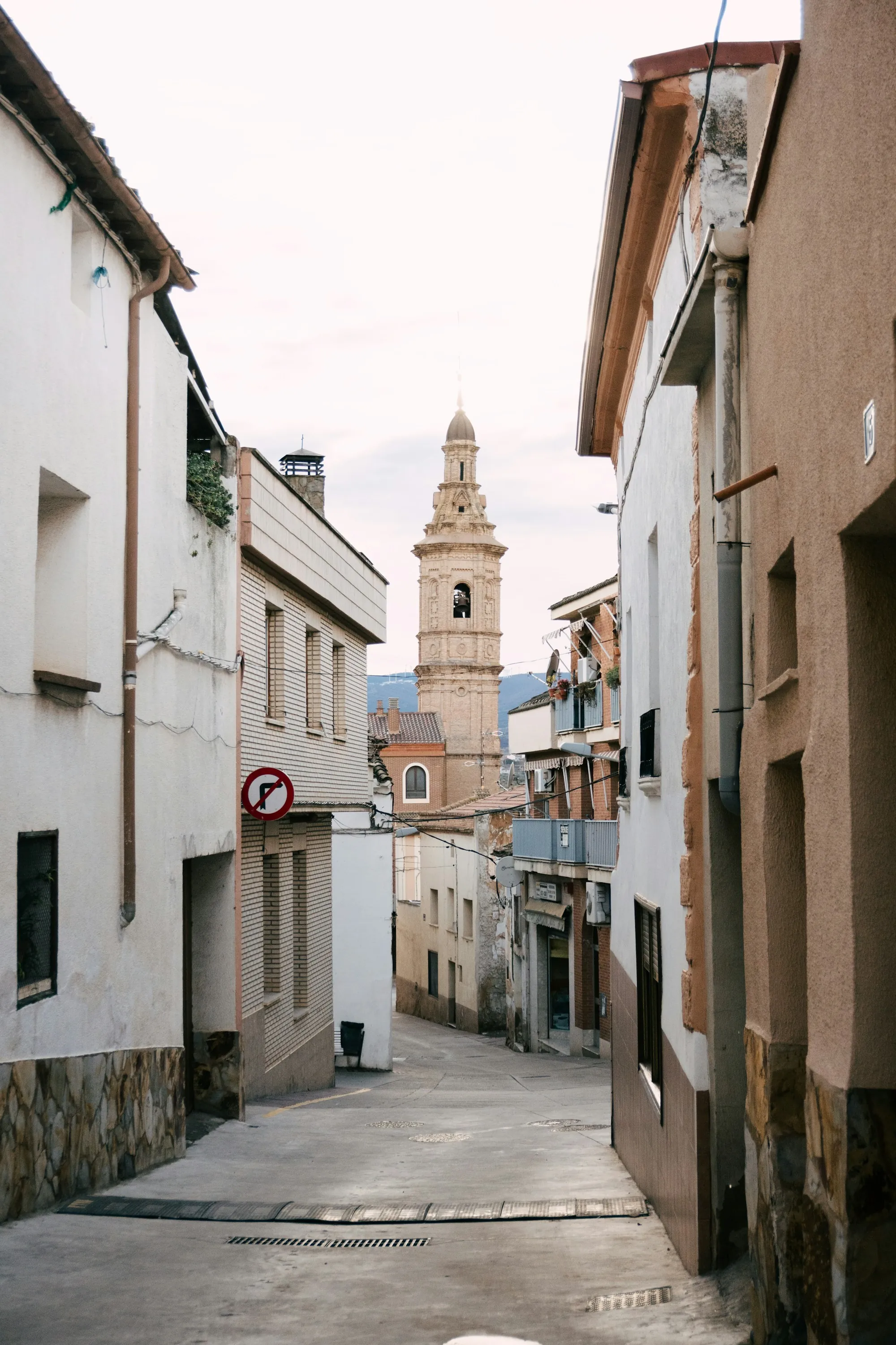 A narrow street below a clock tower